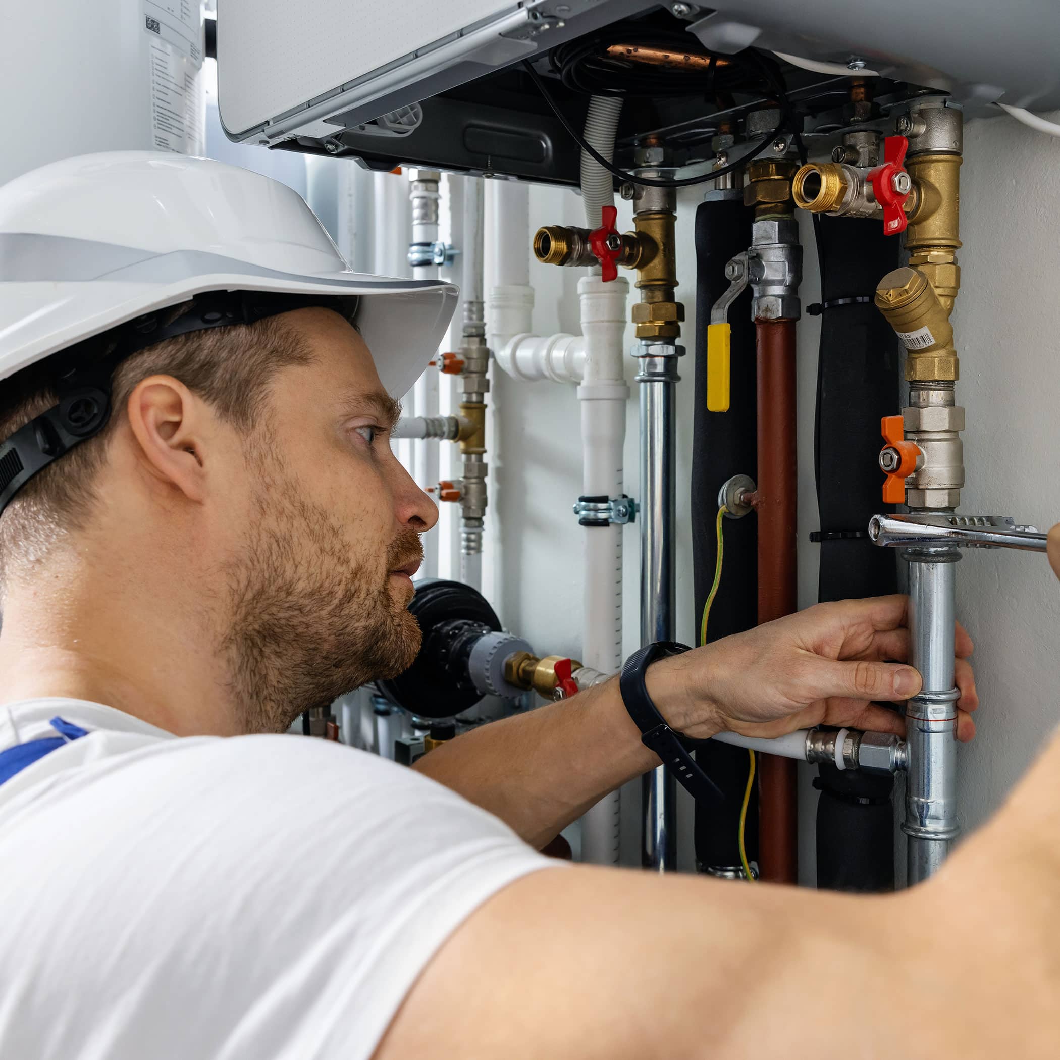 worker installing pipes of house gas heating boiler