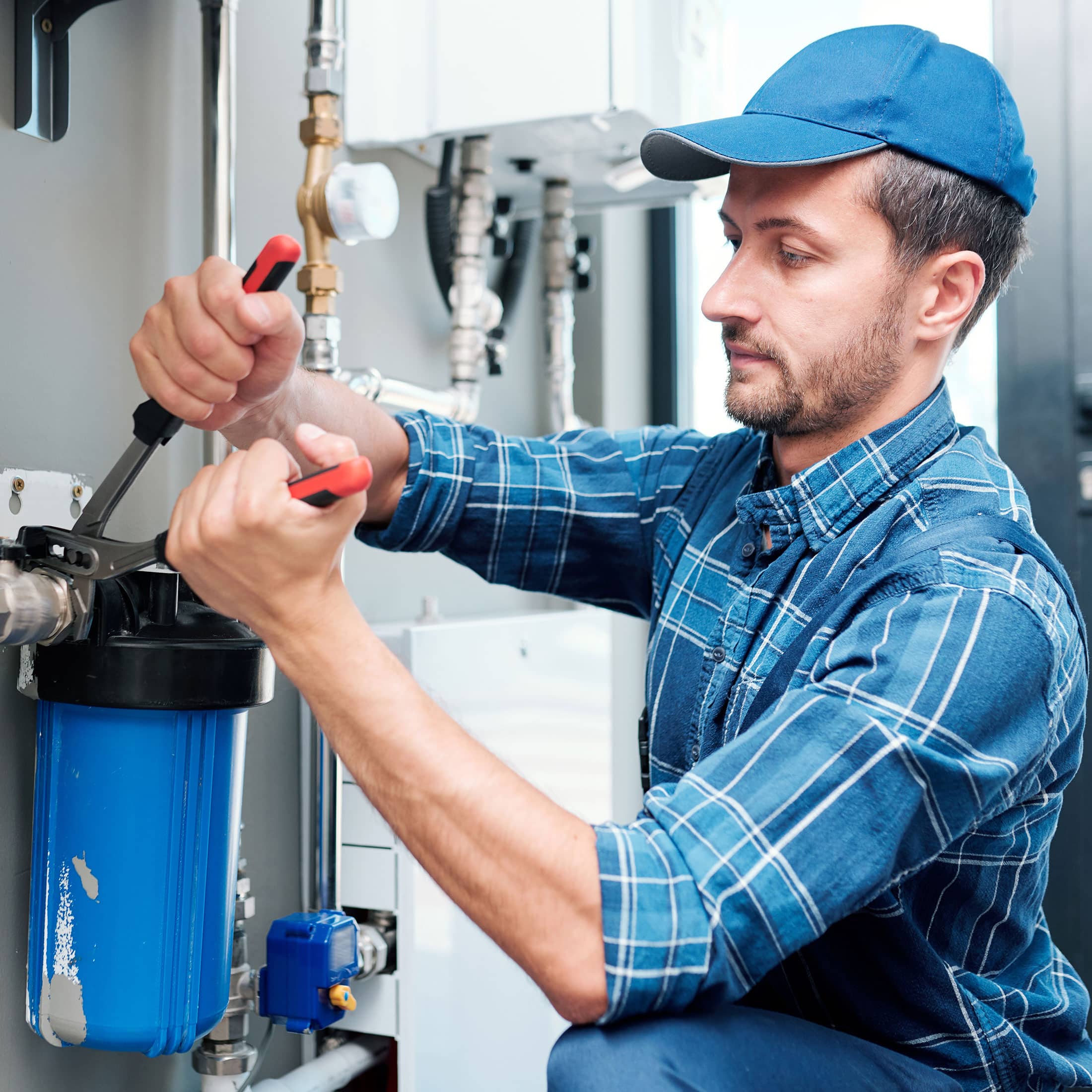 Workwear using pliers while installing water filtration system