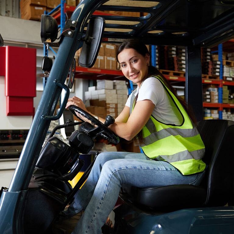 portrait female worker driving a forklift in the warehouse storage